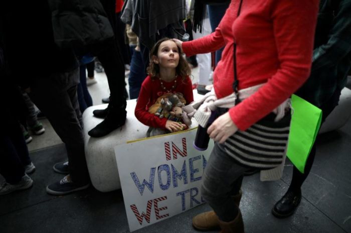 Ada Kennedy, 7, looks up at her mother as they participate in a protest march for survivors of sexual assault and their supporters in Hollywood, Los Angeles, November 13, 2017.