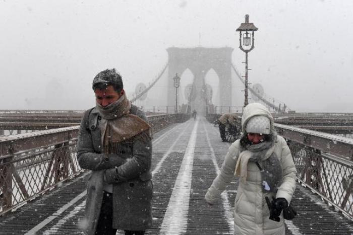 Pedestrians walk through blinding snow across the Brooklyn Bridge during Storm Grayson in New York City, January 4, 2018.