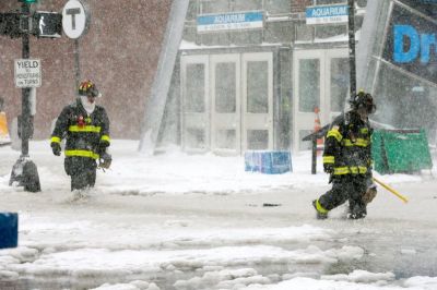 Boston firefighters wade through a street flooded from tidal surge during Storm Grayson in Boston, Massachusetts, U.S., January 4, 2018.