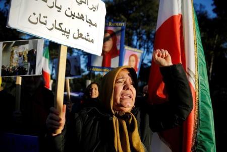 Opponents of Iranian President Hassan Rouhani hold a protest outside the Iranian embassy in Rome, Italy, January 2, 2018. The placard says: 'Brave Iranian! Mujahideen is your friend! Fire will be your battle!'