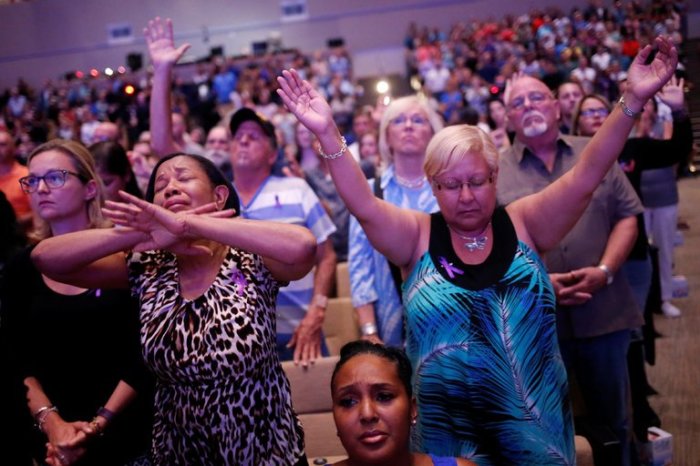 Credit : A group prays during a memorial service at the First Baptist Church of Orlando to mourn the 49 victims who died at the Pulse nightclub in June 2016.