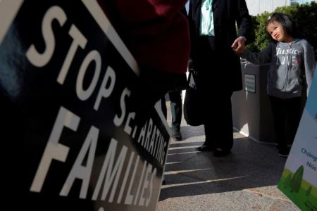 Demonstrators holding an 'Interfaith Prayer Vigil for Immigrant Justice' talk to ethnic Chinese Christians who fled Indonesia after wide scale rioting decades ago and overstayed their visas in the U.S., following their family meeting, including their five year-old daughter (R), with ICE, in Manchester, New Hampshire, U.S., October 13, 2017.