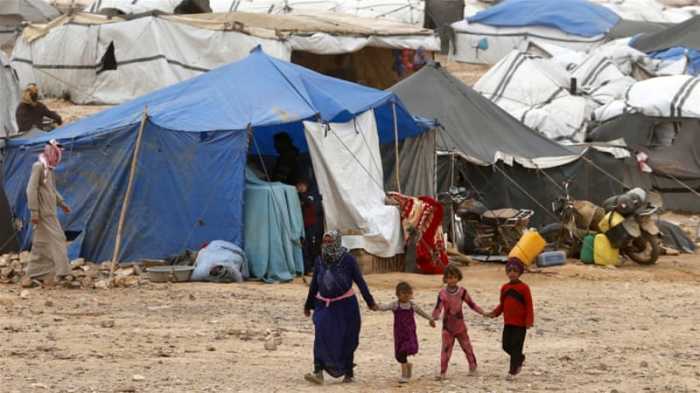 Syrian refugees stuck between the Jordanian and Syrian borders wait to cross into Jordan in this undated photo.