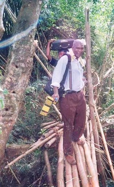 Pastor James Cuffee of Christ Evangelistic Fellowship Ministries in Liberia crosses a monkey bridge in this undated photo.