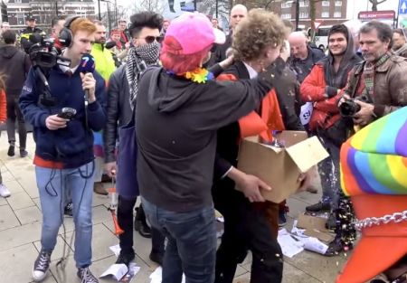 A masked LGBT activists shoves glitter in the eyes of a protester participating in a demonstration led by the Catholic pro-family group Stichting Civitas Christiana in Nijmegen, Netherlands on March 11, 2018.