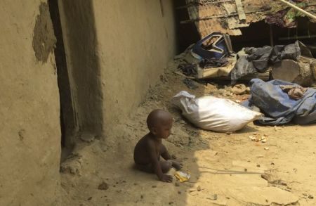 A Rohingya baby sits in the dirt outside of a hut in the Kutupalong Refugee Camp in Cox's Bazar, Bangladesh. March, 2018.