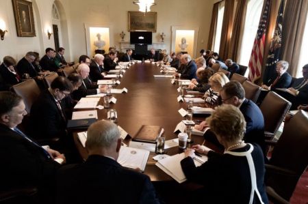 President Donald Trump prays with members of his cabinet at the White House on April 9, 2018.