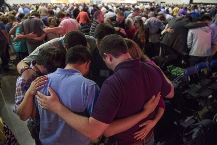 Small groups of messengers pray at the Southern Baptist Convention's annual meeting.