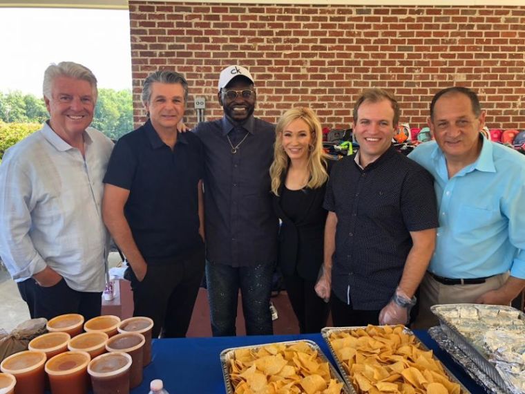 Evangelical leaders including Jack Graham, Paula White, Johnnie Moore, Jentezen Franklin and Harry Jackson pose for a picture while serving lunch to immigrant children at the Youth for Tomorrow residential campus in Bristow, Virginia on July 13, 2018.