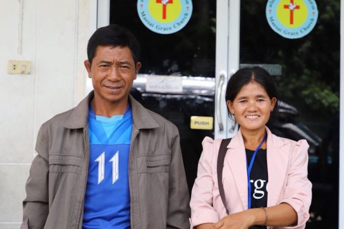 The happy parents of the sponsored boy who has been rescued from the cave in Thailand standing outside of the church where their son attends the Compassion program.