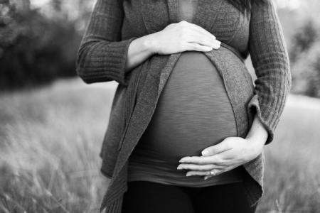 An expecting mother caresses the child in her womb