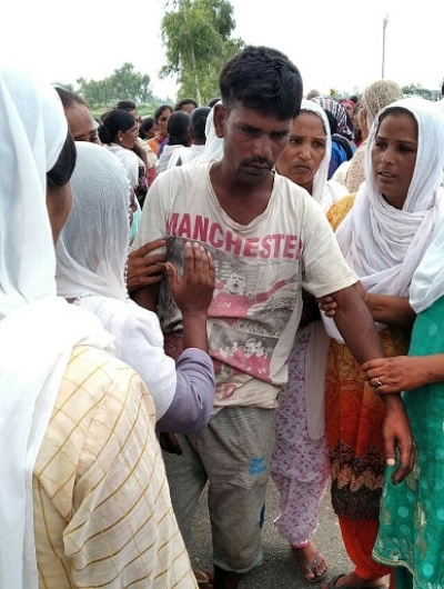 The girl's father is comforted by local women.