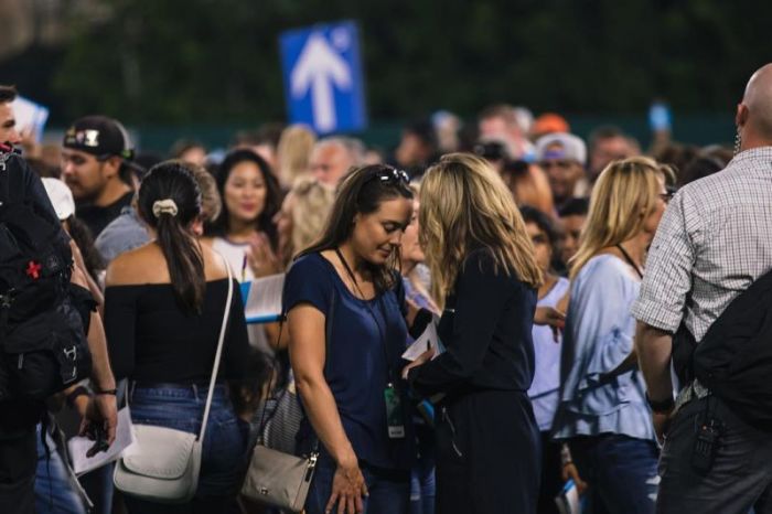 Women pray in the outfield during the 2018 Southern California Harvest at Angel Stadium in Anaheim, California, on Aug. 19, 2018.