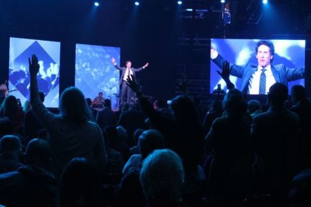 Attendees lift their hands in prayer during televangelist Joel Osteen's 'Night of Hope' event at Capital One Arena in Washington, D.C. on Oct. 6, 2018.