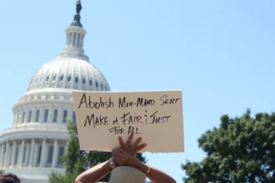 Credit : A demonstrator holds up a sign during a rally held outside of the United States Capitol Building in Washington, D.C., to call for criminal justice reform and the passage of the FIRST STEP Act on July 10, 2018.