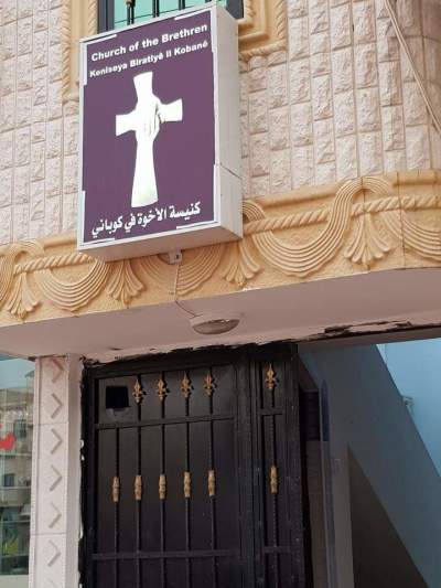 A sign hangs outside of the new Church of the Brethren located in the Syrian city of Kobane in northeast Syria in December 2018. Kobane is home to a community of Kurdish Christian converts. 