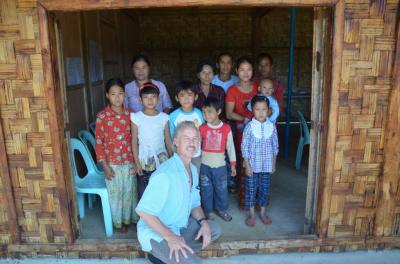 Greg Buckingham kneels down for a picture with children from an orphanage in Myanmar. 