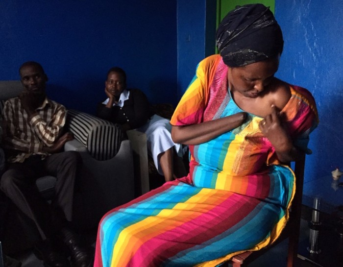 Alice Mukarurinda (R) shows reporters the scar that remains from being speared in the shoulder by one of the colleagues of Emmanuel Ndayisaba (L). She also has scars remaining on her head in addition to the loss of her hand. The two are now are now good friends despite being victim and perpetrator during the Rwandan genocide of 1994. 