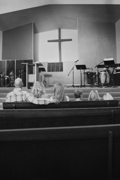 Morgan Idleman (2nd from L) sits with her family, including Pastor Shane Idleman, in church.