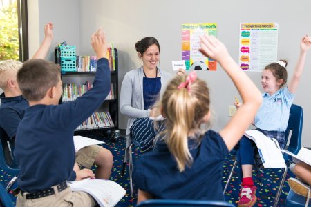 Students at Twelve Stones Christian Academy in northern Kentucky raise their hands during class. 