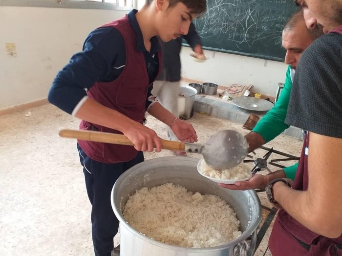 A Partners Relief & Development team member hands out of food to displaced people in Hasakah, Syria, in October 2019. 