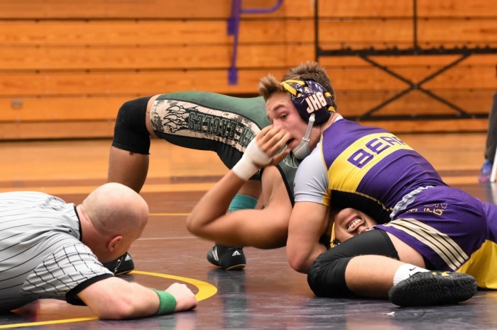 High school wrestlers square off in a match. 