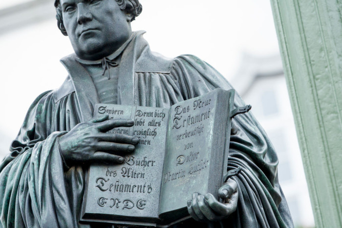 A statue of 16th-century theologian Martin Luther holds a Bible in the hand on the marketplace during the celebrations to commemorate the 500th anniversary of Luther's nailing of his 95 theses on the doors of the nearby Schlosskirche church on October 31, 2017 in Wittenberg, Germany. 