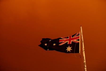 The Australia Flag flies under red skies from the fires on Jan. 4, 2020, in Bruthen, Australia. 