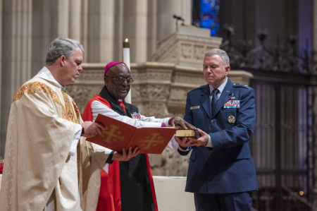 The Rev. Randolph Hollerith, dean of the Washington National Cathedral (from left); the Rev. Carl Wright, the Episcopal Church's bishop suffragan for the armed forces; and Maj. Gen. Steven Schaick, the Air Force chief of chaplains, participate in the blessing of a Bible for swearing in U.S. Space Force officials.