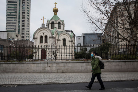 A woman wears a protective mask as she passes a church on February 8, 2020, in Wuhan, Hubei province, China. The number of those who have died from the Wuhan coronavirus, known as 2019-nCoV, in China climbed to 724. 