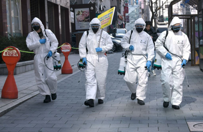 South Korean soldiers wear protective gear spray disinfectant on the street to help prevent the spread of the COVID-19 coronavirus, at Gangnam district in Seoul on March 5, 2020. 