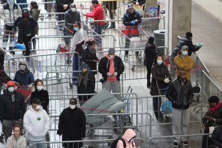 Customers practice social distancing while waiting for a Costco warehouse to open in Manhattan, New York, on March 29, 2020.