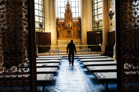 A volunteer sets up beds in what will be a field hospital in the Cathedral Church of St. John the Divine on April 8, 2020, in New York City.