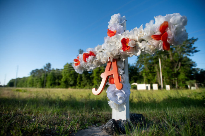 A cross with flowers and a letter A sits at the entrance to the Satilla Shores neighborhood where Ahmaud Arbery was shot and killed on Feb. 23 in Brunswick, Georgia, on May 7, 2020. 