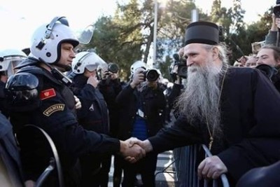 Bishop Joanikije greets police and appeals for calm outside of the Parliament of Montenegro in the capital Podgorica, before the new law compelling state registration of religious groups and church property was passed, December 2019.