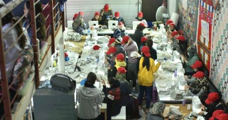 Refugees at the Moria Camp in Lesbos, Greece, produce cotton face coverings. 