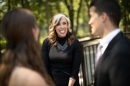 Kristi Stokes (center), owner of Covenant Weddings in Cuyahoga County, Ohio, interacts with a bride and groom at a wedding photo shoot.