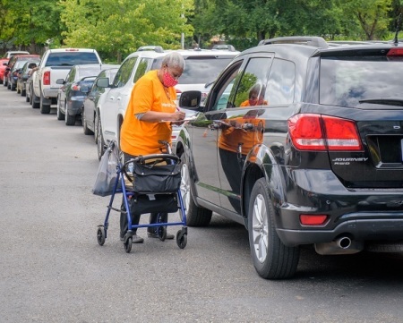 World Vision volunteer helps serve a line of families waiting to receive food from the Fresh Food Box Program. The program has served over 840,000 Americans nationwide.