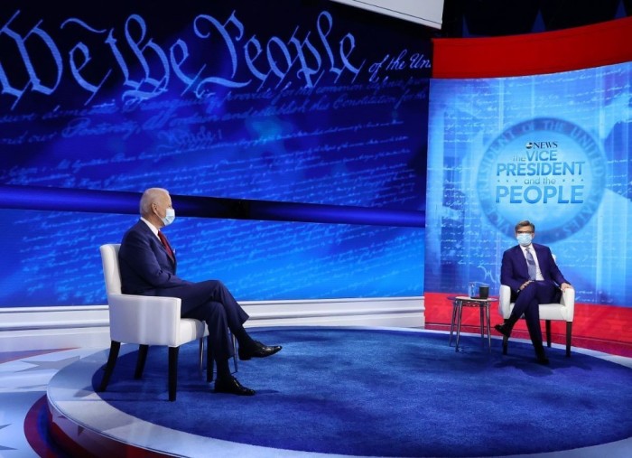 Democratic presidential nominee Joe Biden and ABC News Chief Anchor George Stephanopoulos pose for photographs at the beginning of a town hall format meeting at the National Constitution Center October 15, 2020 in Philadelphia, Pennsylvania. 