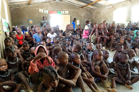 Himba children and adults gathered inside of the church building for dedication service