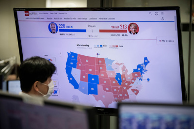 A foreign exchange trader monitors screens as results are broadcast from the United States election, on November 4, 2020 in Tokyo, Japan. After a record-breaking early voting turnout, Americans head to the polls on the last day to cast their vote for incumbent U.S. President Donald Trump or Democratic nominee Joe Biden in the 2020 presidential election. 