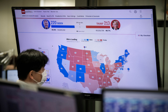 A foreign exchange trader monitors screens as results are broadcast from the United States election, on November 4, 2020 in Tokyo, Japan. After a record-breaking early voting turnout, Americans head to the polls on the last day to cast their vote for incumbent U.S. President Donald Trump or Democratic nominee Joe Biden in the 2020 presidential election. 