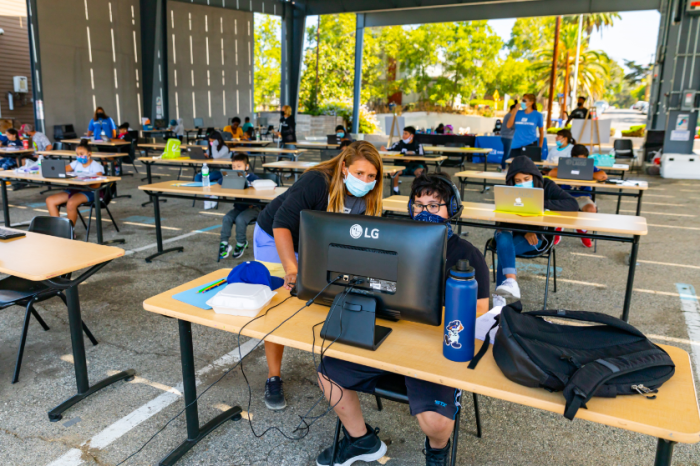 A tutor assists a student at the Restart Learning Center, a distance learning center set up at the Los Angeles Dream Center, a faith-based nonprofit based in the Echo Park Neighborhood of Los Angeles, 2020.