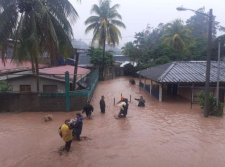 People walk around buildings flooded by the heavy rains caused by Hurricane Iota in Jinotega, north of Nicaragua, November 2020.