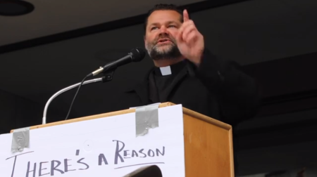 Father Theodore Lange, chaplain of the Oregon Knights of Columbus, protests against the state's coronavirus limits on church attendance outside the Oregon Capitol on Nov. 28, 2020.