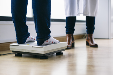 Close-up of a woman on scales in medical practice.