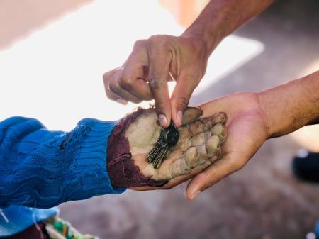 A widow is handed a set of keys to a new home. 