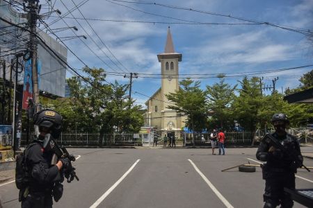 Indonesian police stand guard as they seal the area after an explosion outside a church in Makassar, Indonesia, on March 28, 2021.