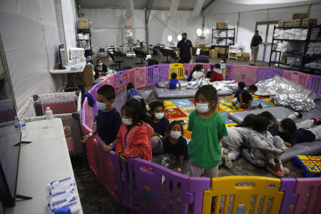 Young unaccompanied migrants, ages 3-9 watch TV inside a playpen at the Donna Department of Homeland Security holding facility, the main detention center for unaccompanied children in the Rio Grande Valley in Donna, Texas, March 30, 2021. The youngest of the unaccompanied minors are kept separate from the rest of the detainees. 