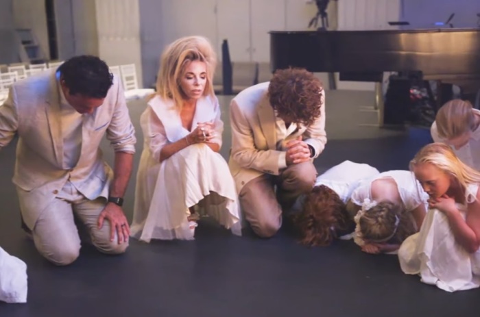 Gwen Shamblin Lara and Joe Lara (L) pray with children.